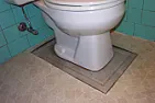 What's this toilet base thingy? |  Have you had the toilet up?  Sometimes older bathrooms had the draincenterline...